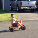 Riding his tricycle!  As soon as his training wheels (they got broke in the move) are replaced we're going to start riding that!  